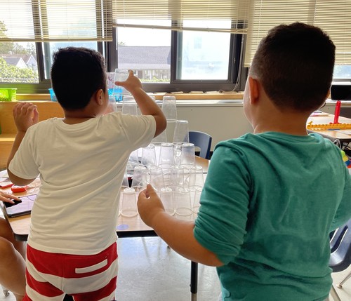 Students practiced collaboration and problem-solving while building towers out of plastic cups.